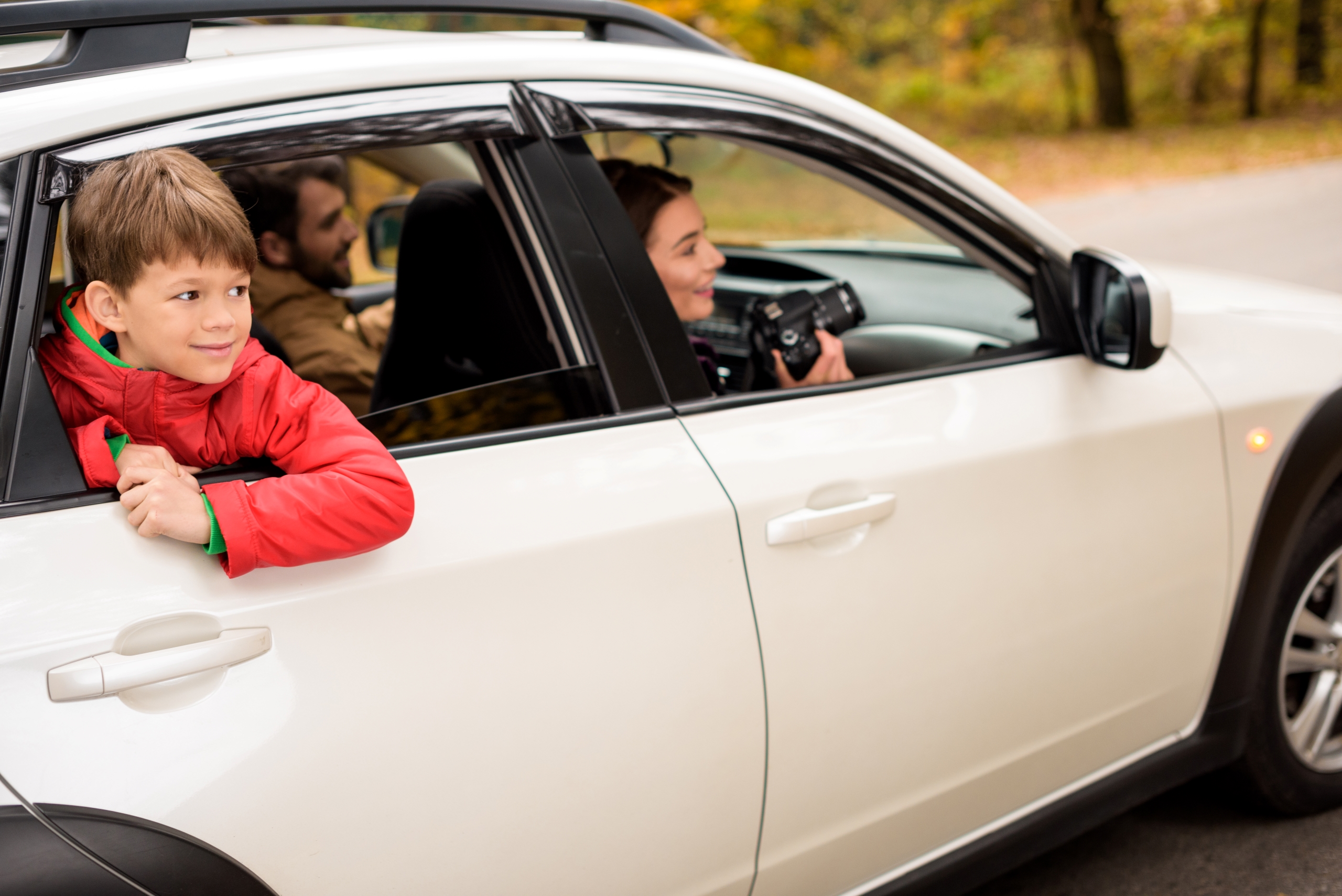 cute-smiling-boy-looking-through-car-window-while-2023-11-27-05-26-42-utc1
