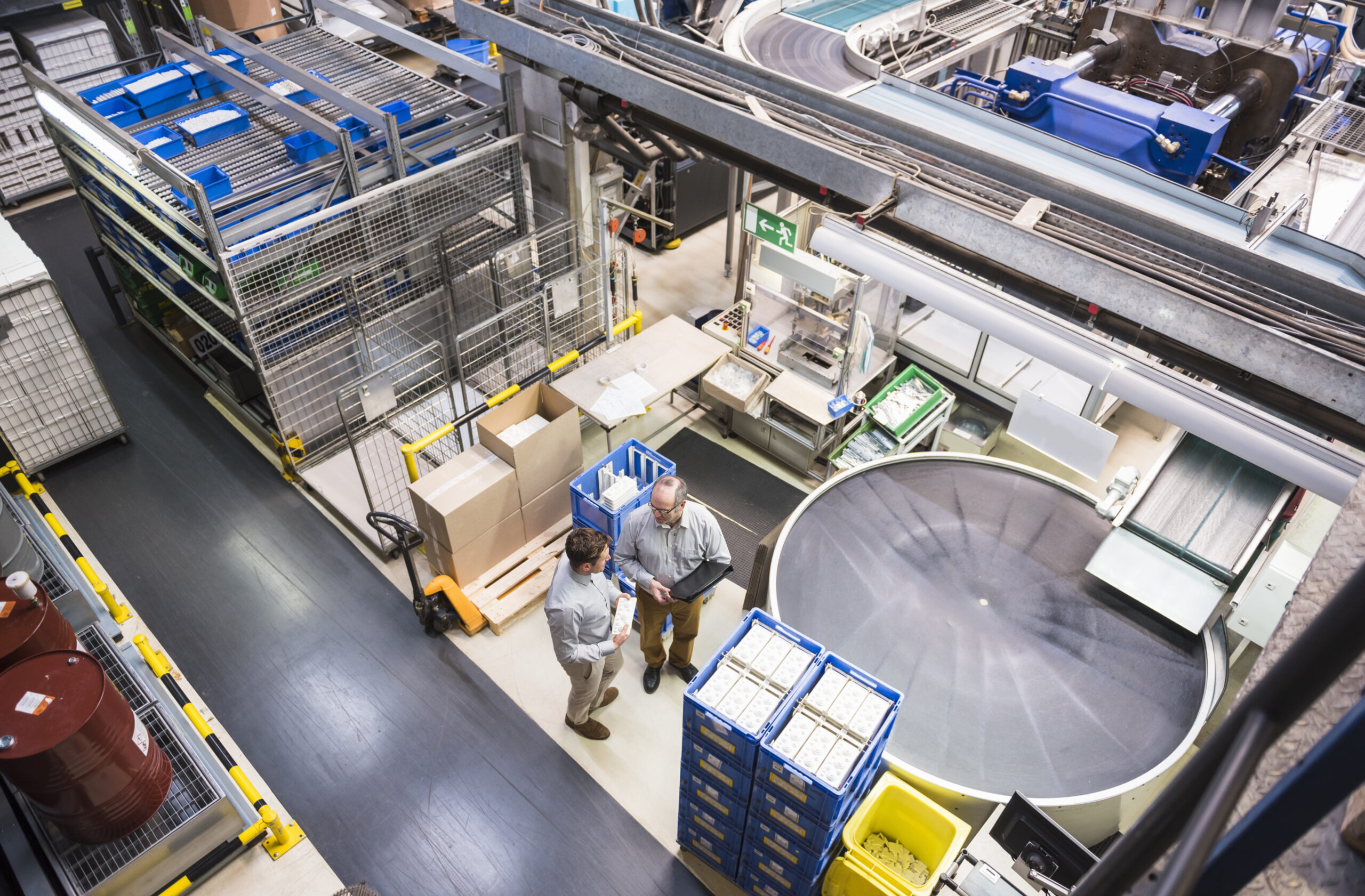 Top view of two men talking in factory shop floor